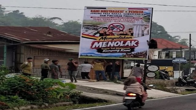 Pemasangan spanduk penolakan trase Jalan Tol Sicincin-Bukittinggi di tepi jalan nasional Padang Panjang-Bukittinggi